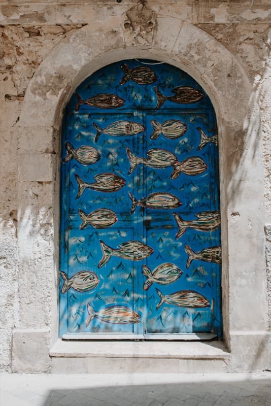 Colorful fish painted on a blue door in Sicily