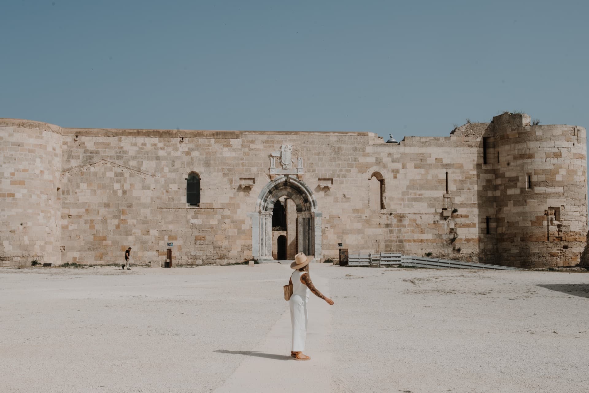 Kat walking through a medieval Sicilian castle courtyard