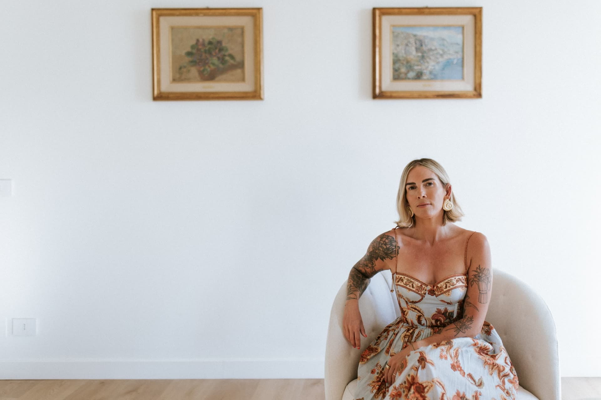 Kat seated in the Lula Mare living room beneath two gilt paintings