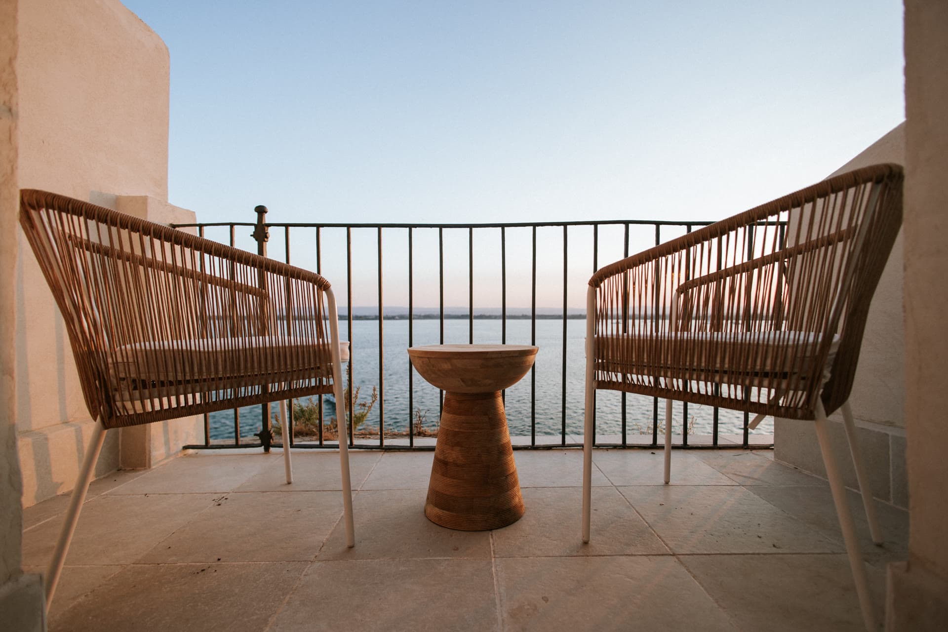 Two rattan chairs on the Lula Mare balcony, facing the open sea