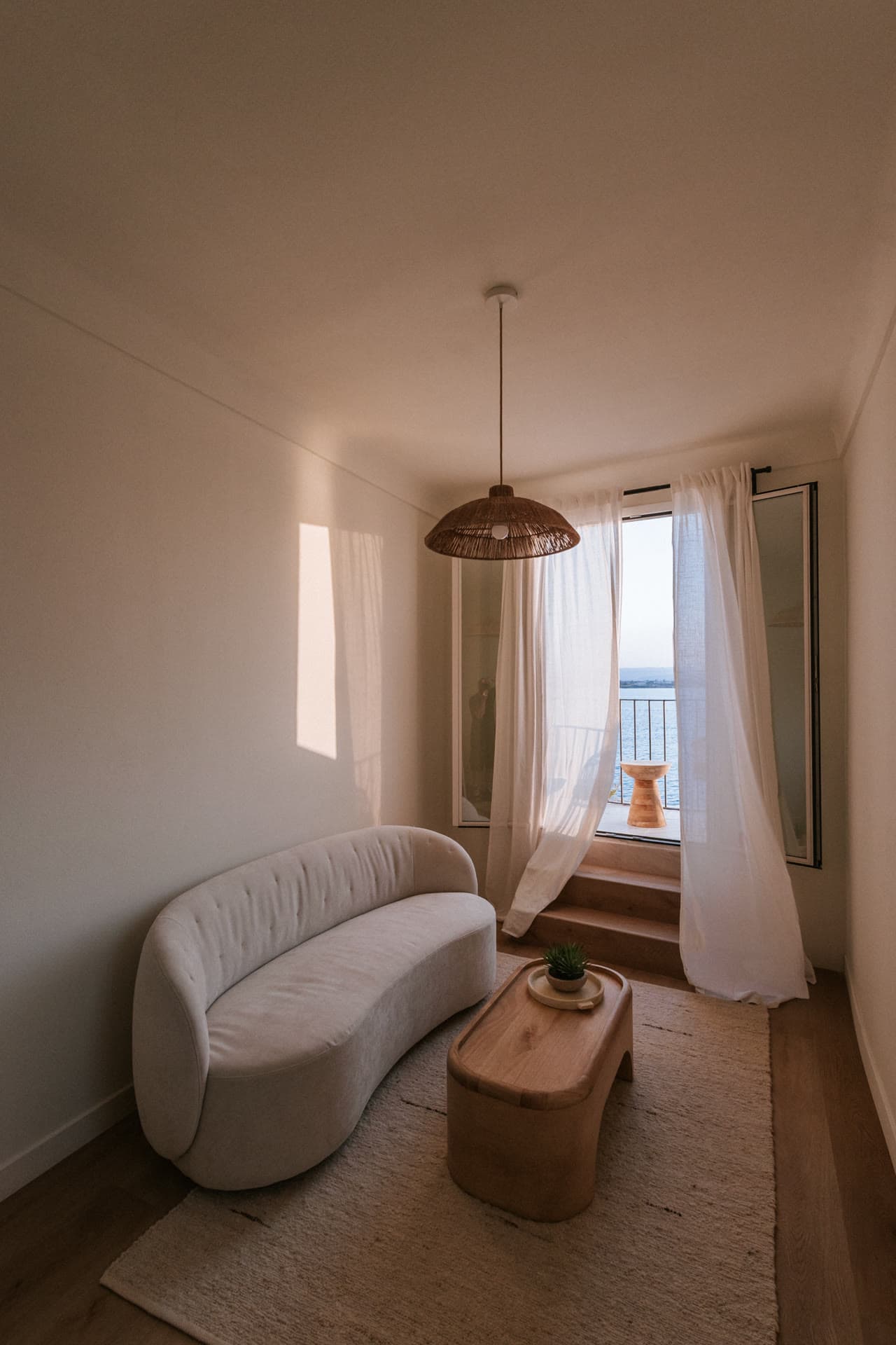 The Lula Mare sitting room, curtains drifting toward the sea