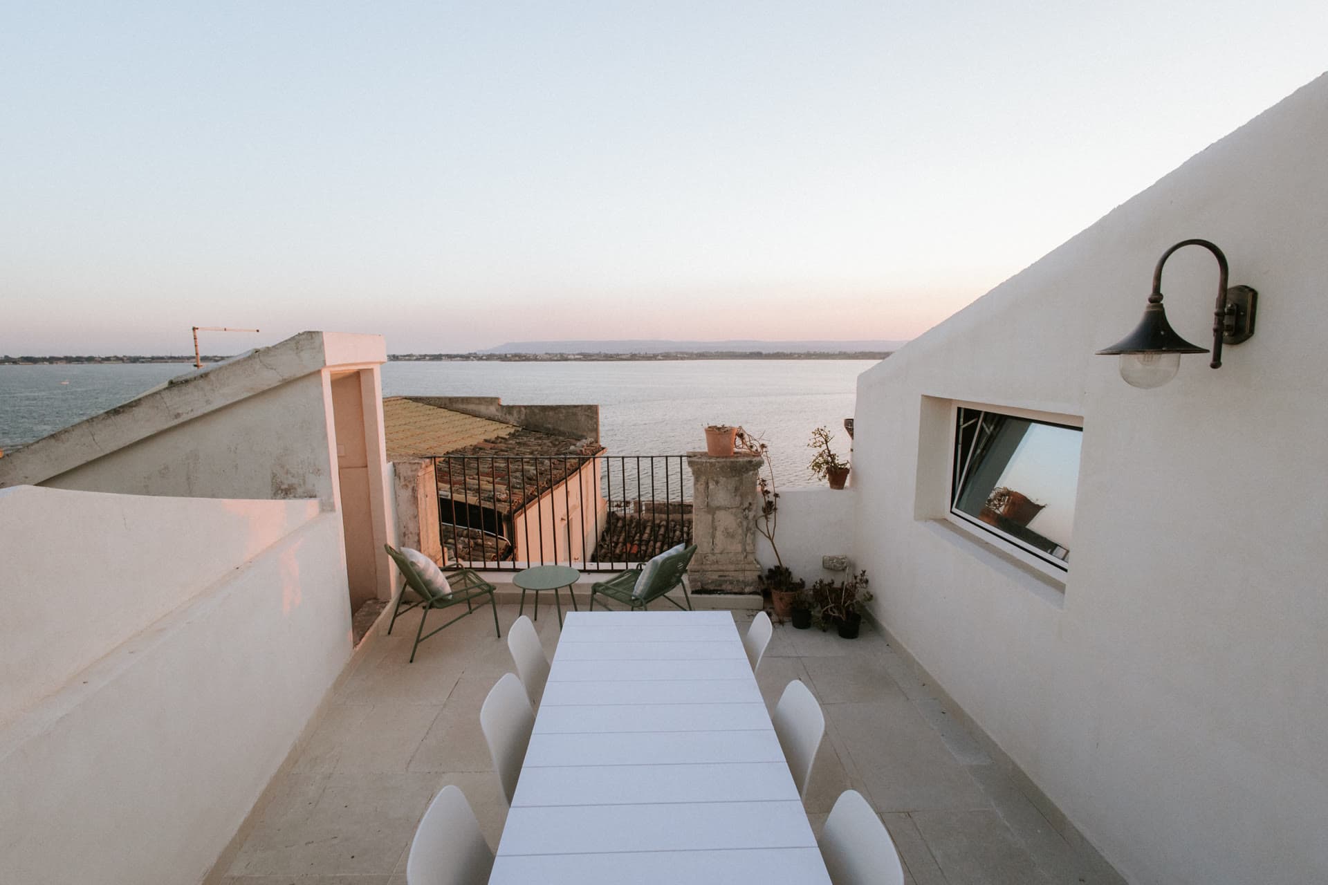The Lula Mare rooftop terrace with a long dining table above the sea